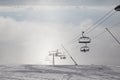 Skiers ride the chairlift in the fog. Royalty Free Stock Photo