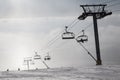 Skiers ride the chairlift in the fog. Royalty Free Stock Photo