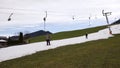 Skiers ride up the mountain in the skilift (T-bar lift)