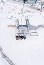 Skiers ride up the mountainside on a ski lift Royalty Free Stock Photo