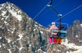 Skiers sitting on ski lift chair