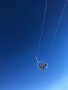 Skiers on a Ski Chair Lift In a Resort With Blue Sky Royalty Free Stock Photo