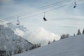 Skiers in ski lift high in snowy cloudy mountain