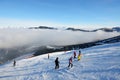 The skiers are on slope and fog in Jasna Low Tatras