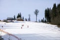 skiers on a snow slope for beginners on a sunny day.