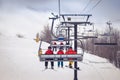 Skiers and snowboarder on a chairlift