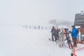 Skiers and snowboarders exiting ski lift on a top of a mountain, low visibility due to heavy mist, Andorra Royalty Free Stock Photo