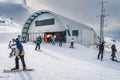 Skiers and snowboarders exiting ski lift on the top of a mountain. Ski winter holidays in Andorra