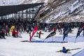 Skiers and snowboarders are gathered in front of the main building at The Remarkables ski resort.