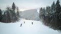 Skiers and snowboarders go down the slope in a ski resort Bukovel, Ukraine