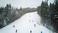 Skiers and snowboarders go down the slope in a ski resort Bukovel, Ukraine