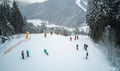 Skiers and snowboarders go down the slope in a ski resort Bukovel, Ukraine