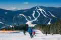 Skiers and snowboarders going down the slope at ski resort Royalty Free Stock Photo