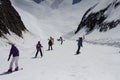 Skiers and snowboarders going down the slope at Royalty Free Stock Photo