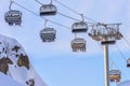 Skiers and snowboarders ride on chair ski lift at Gorky Gorod mountain ski resort in Sochi, Russia, against blue sky at winter Royalty Free Stock Photo