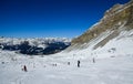 Skiers and snowboarders riding on a ski slope on a beautiful sunny winter day.