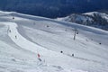 Skiers and snowboarders riding on a ski slope in mountain resort snowy winter Royalty Free Stock Photo