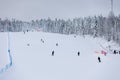 Skiers and snowboarders on a snowy slope in a ski resort in Finland. Royalty Free Stock Photo