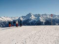 Skiers on top of red slope