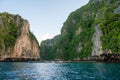 Boats on the blue water of the ocean surrounded by cliffs