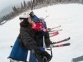 Skiing, ski lift, ski resort - happy smiling family skiers on ski lift making selfie Royalty Free Stock Photo