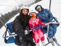 Skiing, ski lift, ski resort - happy smiling family skiers on ski lift making selfie Royalty Free Stock Photo