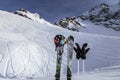 Skiing and ski poles stand vertically in the snow against the background of the ski descent Royalty Free Stock Photo