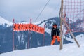 Skiing in the snow. One Asian girl sitting on ski lift by grabbing the rope and holding ski sticks. Vacation in Switzerland Royalty Free Stock Photo