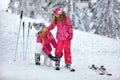 Skiing, winter fun-smiling mother preparing for skiing daughter Royalty Free Stock Photo