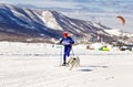 Skijoring man skiing runs with dog in harness.