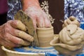 Skilful craftsman hands form a clay bowl on a traditional pottery wheel, ethnography study