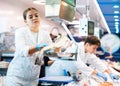 Skilful shop assistant weighing cod fish on scales in fish store Royalty Free Stock Photo