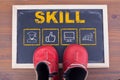 Skill Business concept and kid shoes on on chalkboard and wooden backgroundr Royalty Free Stock Photo