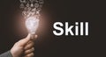 Skill concept. Abstract luminous light bulb in hands, knowledge, qualification and experience symbols fly out from it
