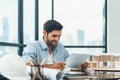 Skilled architect engineer holding blueprint on desk in modern office. Tracery. Royalty Free Stock Photo