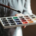Skilled artist mixing watercolor paints with brush