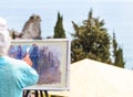 Skilled artist painting nature on easel outdoors