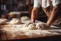 Skilled baker kneading dough in bakery for baking bread bright photo with blurred background