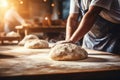 Skilled baker kneading dough for baking bread in bakery with copy space on blurred background