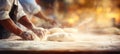 Skilled baker kneading dough for bread in bakery, blurred background and text space bright photo.