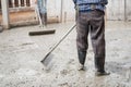 Skilled builder expertly pours cement on the floor, sculpting a solid foundation for the house with meticulous plastering skills.