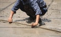 Skilled builder expertly pours cement on the floor, sculpting a solid foundation for the house with meticulous plastering skills.