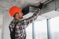 Construction worker repairing air conditioning ventilation system Royalty Free Stock Photo
