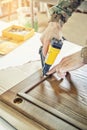 Skilled carpenter assembles wooden door fixing glazing bead