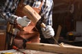 Skilled carpenter carving wood with hammer and chisel