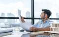 Skilled architect engineer holding blueprint on desk in modern office. Tracery. Royalty Free Stock Photo