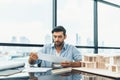 Skilled architect engineer holding blueprint on desk in modern office. Tracery. Royalty Free Stock Photo