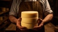 Skilled cheesemaker presents his carefully crafted cheese wheel, a symbol of his dedication to the craft. cheese in Royalty Free Stock Photo