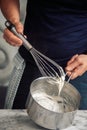 chef holding a white bÃ©chamel sauce on a whisk