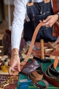 skilled craftsman in apron working with leather at workshop Royalty Free Stock Photo